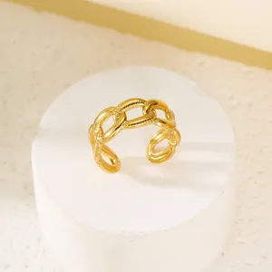 Nahaufnahme eines vergoldeten Edelstahlrings im Vintage-Ketten-Design auf weißem Sockel