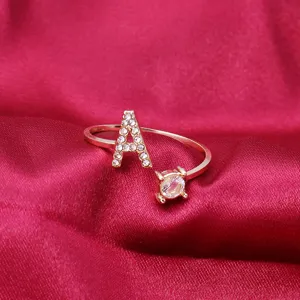 Detail of adjustable gold ring with rhinestone letter A and a sparkling round crystal