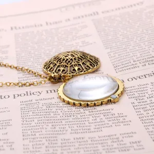 Macro view of vintage bronze filigree magnifying glass pendant necklace on newspaper