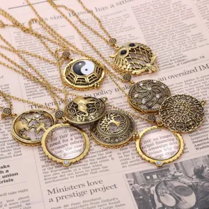 Close-up of vintage bronze magnifying glass pendants with intricate hollow carvings.