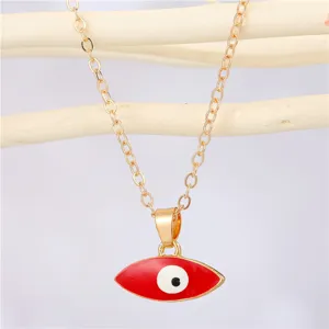 Close-up of red Evil Eye pendant necklace with gold chain on natural wood background