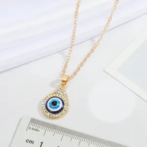 Detailed view of a crystal-rimmed gold Turkish Evil Eye teardrop pendant necklace