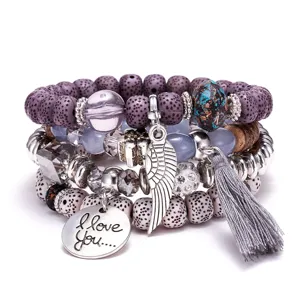 Bohemian 4-piece natural stone stackable bracelet set featuring wing charm, tassel and tags.