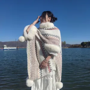 Boho-Strickponcho mit Kunstfellkragen aus Kaninchenimitat und verspielten Bommeln