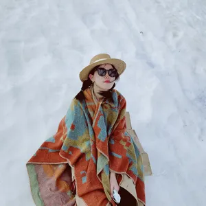 Vintage ethnic style thick warm shawl poncho wrap worn by model on snowy background