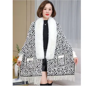 Elegant leopard print knitted poncho with a plush white fur collar and fringe hem detail.