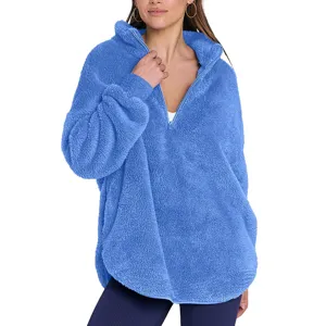 Gros plan sur le sweat-shirt molletonné bleu roi à col zippé, texture peluche douce.