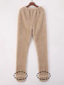 Pantalón de pijama de felpa gruesa con calcetines integrados detalle de textura.