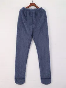Detalle de pantalón de dormir de felpa gruesa, diseño de calcetines integrados, suave y cálido.