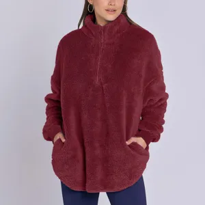 Gros plan sur la texture molletonnée, col zippé montant et détail des poches latérales.