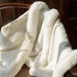 Detail der weichen Kunstpelzbesätze und Strickstruktur des eleganten weißen Brautschals.