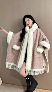 Detailansicht eines Winter-Wollponchos mit Pelzkragen und modischen Fransenquasten
