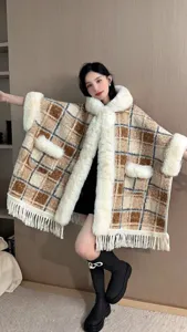 Detailansicht eines Winter-Capes mit Pelzkragen, Karomuster und Fransen-Details.