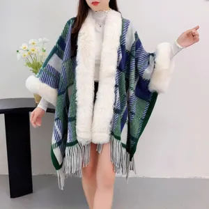 Detailansicht eines grün karierten Strick-Ponchos mit weißem Kunstpelzkragen