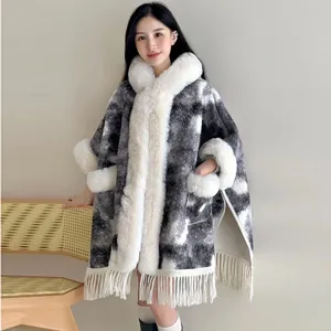 Detailansicht dieses Winterponchos mit Kapuze, weichem Pelzkragen und dekorativen Fransen.