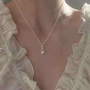 Primer plano de un elegante collar de clavícula con gota de diamante para mujer