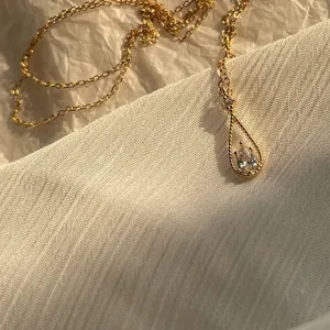 Primer plano de un elegante colgante de gota francés con una piedra brillante tallada en pera