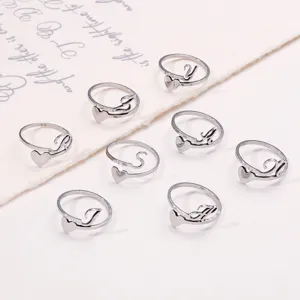 Close-up of stainless steel heart rings with custom script letters on white background.