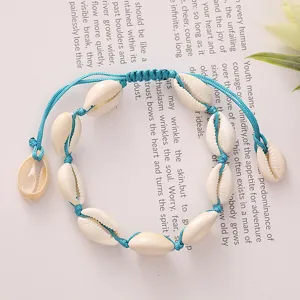 Detailed view of handmade cowrie shell bracelet with adjustable blue woven cord