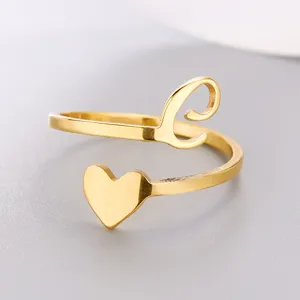 Close-up detail of a gold stainless steel open ring featuring a heart and initial L