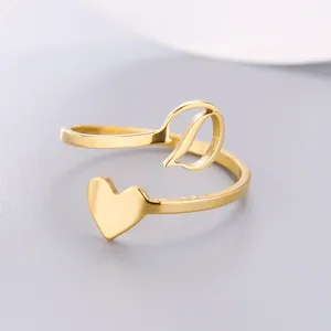 Close-up detail of golden stainless steel open ring with heart and letter D initial design.