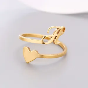 Detailed macro view of a gold-plated heart ring featuring a cursive initial R metal