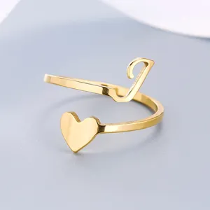 Macro detail of a gold stainless steel open ring with heart and letter L design