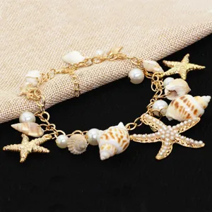 Detailed view of a bohemian gold chain bracelet featuring real seashells and pearls