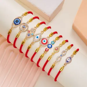 Selection of evil eye red cord bracelets with gold-plated charms and rhinestones.