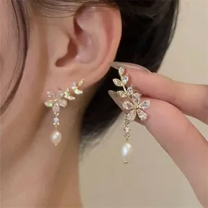 Elegant gold floral earrings featuring marquise-cut stones and dangling white pearl drops