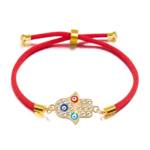 Detailed close-up of a red cord Hamsa Hand bracelet featuring crystal Evil Eye charms
