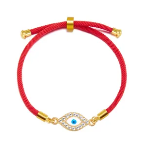 Close-up of adjustable red string bracelet featuring a crystal-encrusted Evil Eye charm.