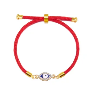 Detail shot of a red cord evil eye bracelet with sparkling rhinestone accents.