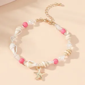 Detail view of a Bohemian shell bracelet with pink beads and a gold starfish charm for summer.