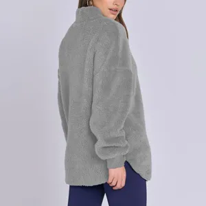 Vue detaillee de la texture du sweat col monte polaire gris pour femme avec bas arrondi.