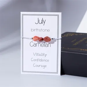 Primer plano de pulsera de cornalina, piedra de nacimiento de julio, en tarjeta