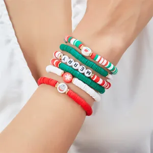 Primo piano di braccialetti natalizi in pasta polimerica con scritte 'MERRY' e ciondoli festivi.