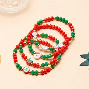 Dettaglio macro di braccialetti natalizi con perline, Babbo Natale e ciondoli HO HO