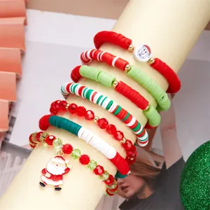 Primo piano di braccialetti natalizi con perline colorate in argilla e ciondolo Babbo Natale.