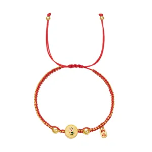 Détail du bracelet tressé rouge l'année du serpent 2025 avec breloque dorée et étiquette