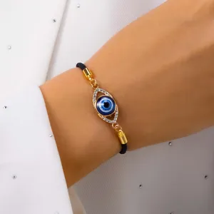Elegant close-up detail of a blue Evil Eye bracelet with crystals on a woman's wrist