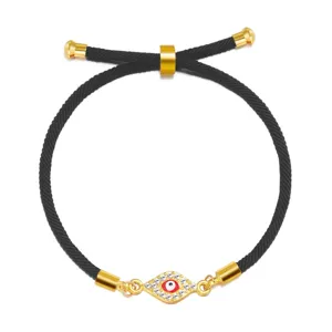 Detailed view of adjustable black rope bracelet with a rhinestone Evil Eye charm