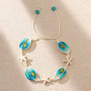 Detail view of Bohemian seashell bracelet with starfish and sea turtle print on cream cord.