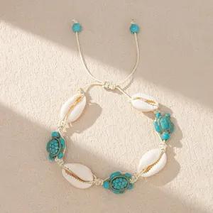 Close-up of Bohemian shell bracelet with turquoise turtle beads for beach vacations.