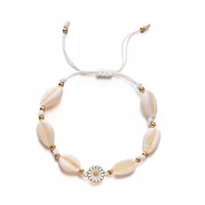 Detailed view of bohemian beach bracelet with cowrie shells and white daisy charm