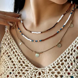 Close-up view of a Bohemian 3-piece layered beaded necklace set with gold disc charms.