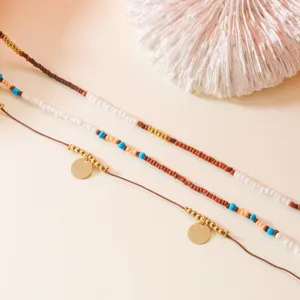 Close-up of Bohemian 3-piece beaded necklace set with gold charms and blue beads