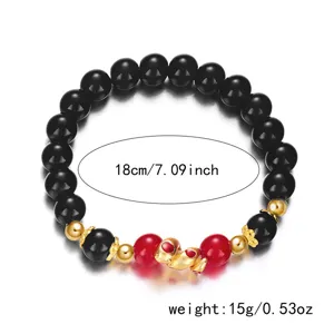 Close-up of Chinese style beaded bracelet with gold snake charm and black beads
