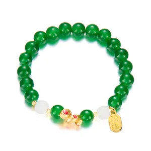Green beaded bracelet featuring a golden snake charm and blessing tag for the 2025 zodiac