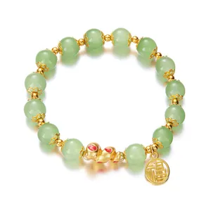 Detailed view of green beaded bracelet with gold-tone snake and Fu character charms